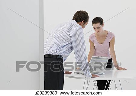Stock Photo - A business couple looking at a laptop. Fotosearch