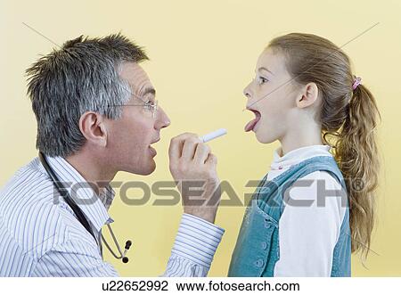 Stock Image - A doctor checks a girls throat. Fotosearch
