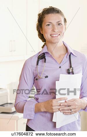 Stock Image - A female doctor holding some notes. Fotosearch
