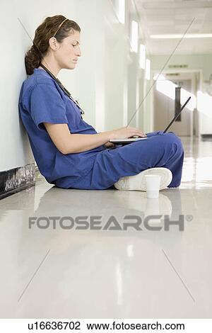 Stock Image - A female doctor on her laptop. Fotosearch