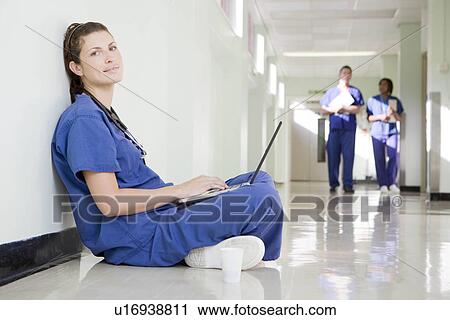 Stock Image - A female doctor on her laptop. Fotosearch