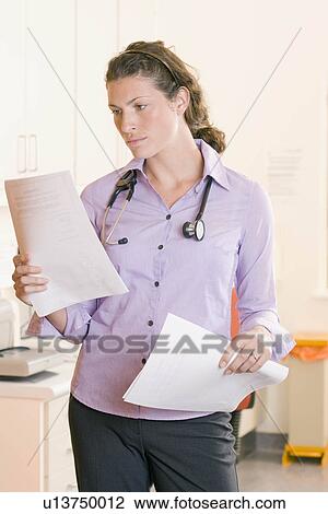 A female doctor reading some notes View Large Photo Image Stock Image - A female doctor reading some notes. Fotosearch