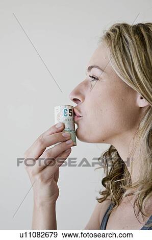 Stock Photo - A female kissing a roll of money.. Fotosearch