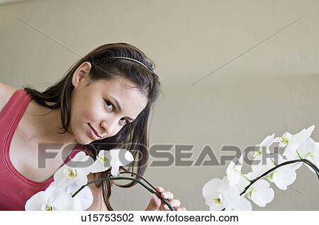 Stock Image - A female smelling an orchid. Fotosearch