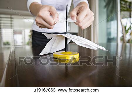 Stock Image - A female spiking her receipts.. Fotosearch