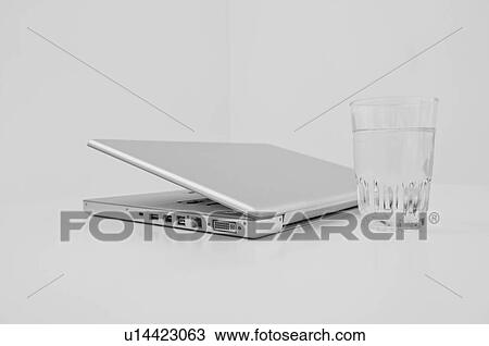 A laptop and a glass of water. View Large Photo Image Stock Image - A laptop and a glass of water.. Fotosearch