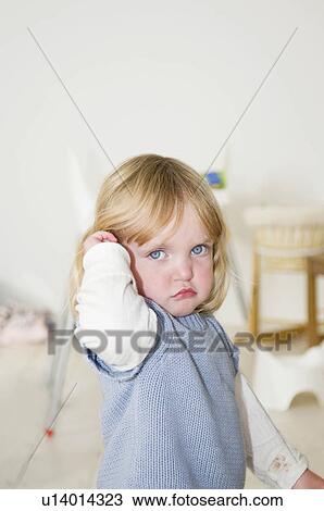 Stock Image - A little girl looking grumpy. Fotosearch