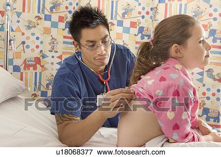 Stock Photo - A male doctor listens to a girls back. Fotosearch