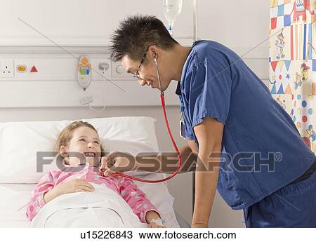 A male doctor listens to a girl’s heart View Large Photo Image Stock Image - A male doctor listens to a girl’s heart. Fotosearch