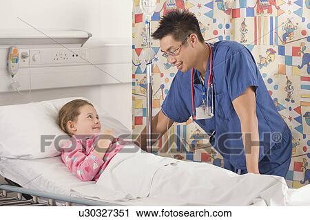 Stock Image - A male doctor visiting a little girl. Fotosearch