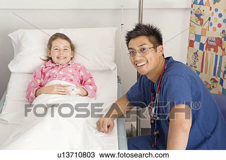 Stock Image - A male doctor visits a sick girl. Fotosearch