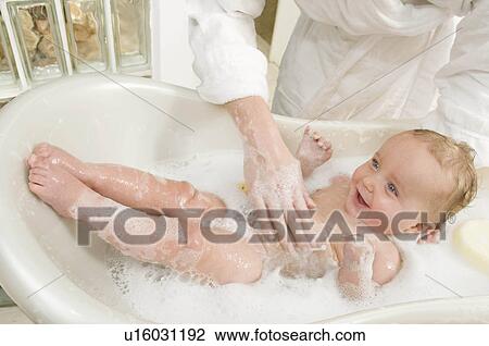 Stock Image - A mother bathing her baby boy. Fotosearch