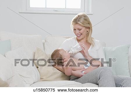 Stock Photography - A mother bottle feeding her child. Fotosearch