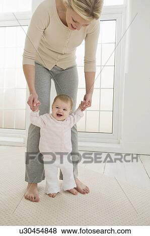 A mother helping her baby to walk. View Large Photo Image Stock Photo - A mother helping her baby to walk.. Fotosearch