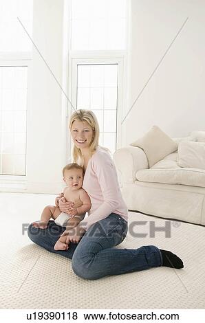 A mother smiling holding her baby View Large Photo Image Stock Photo - A mother smiling holding her baby. Fotosearch