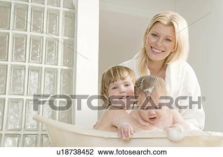 Stock Image - A mum bathing her babies.. Fotosearch