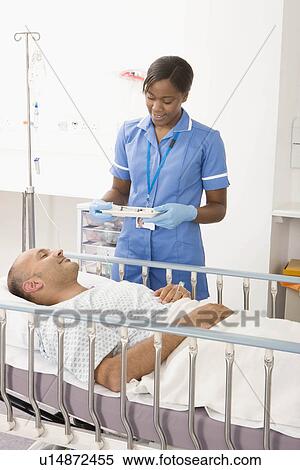 A nurse bringing medication to a patient View Large Photo Image Stock Photography - A nurse bringing medication to a patient. Fotosearch