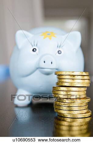 Stock Image - A pile of money and a piggy bank.. Fotosearch