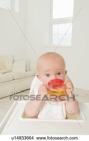 Picture - A portrait of a baby drinking juice.. Fotosearch