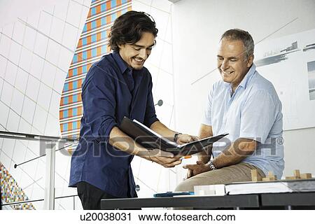 Stock Image - Architects working on a project, smiling. Fotosearch