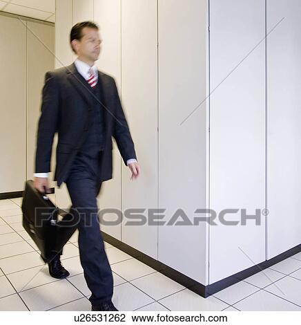 Blurred man walking through office View Large Photo Image Stock Image - Blurred man walking through office. Fotosearch
