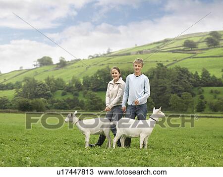 Stock Image - Boy And Girl with Goats. Fotosearch