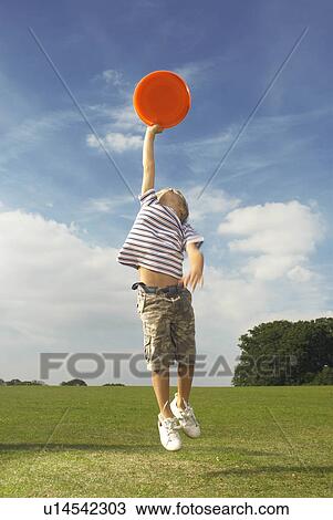 Stock Image - boy catching frisbee. Fotosearch