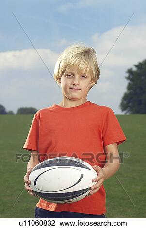 boy holding rugby ball in filed View Large Photo Image Stock Image - boy holding rugby ball in filed. Fotosearch