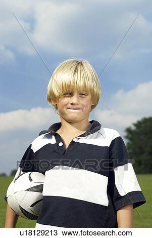 Stock Image - boy holding rugby ball. Fotosearch