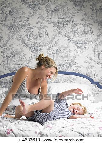 Stock Photo - Boy jumping on his mother's bed. Fotosearch