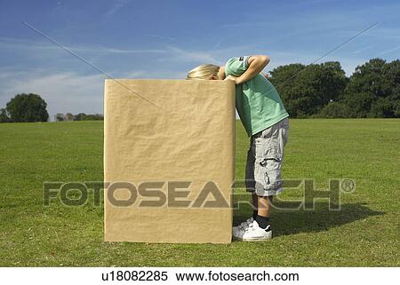 Stock Photography - boy looking into box. Fotosearch