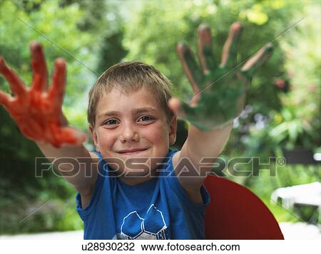Stock Image - Boy showing paint on hands. Fotosearch