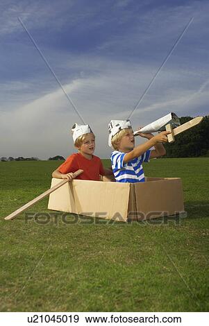 Stock Photo - boys in box pretending to be boat. Fotosearch