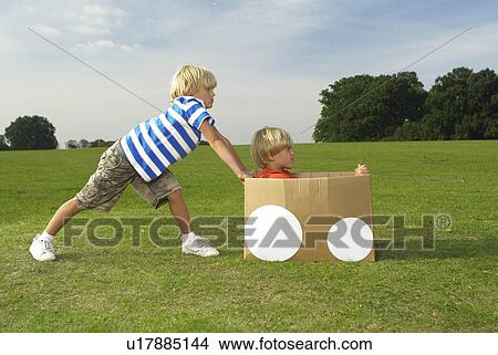 Picture - boys pushing another boy in box. Fotosearch