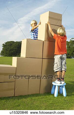Stock Photograph - boys putting box on top of steps. Fotosearch
