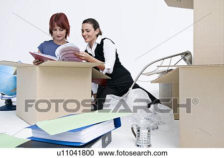 Stock Image - Business colleagues unpack office boxes. Fotosearch