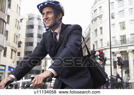 Stock Photo - Business man on a bicycle. Fotosearch