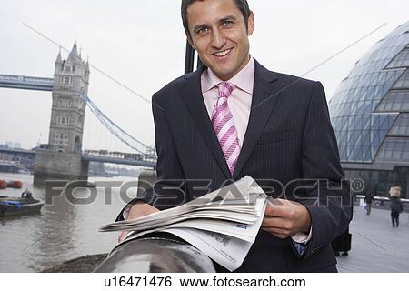 Stock Photograph - Business man reading newspaper outside. Fotosearch