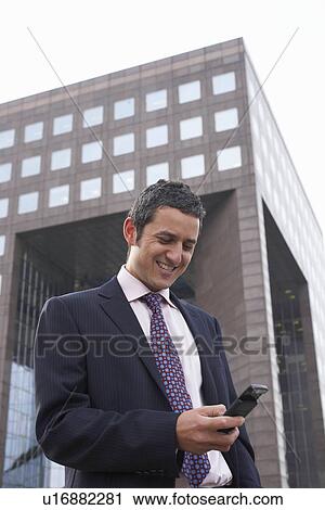 Stock Image - Business man using a mobile phone. Fotosearch