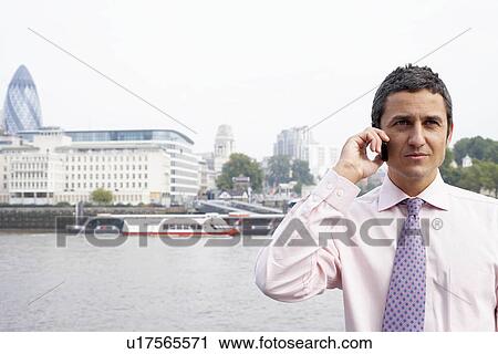 Stock Image - Business man using a mobile phone. Fotosearch