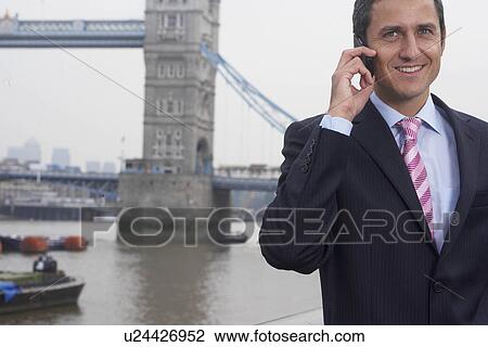 Stock Image - Business man using a mobile phone. Fotosearch