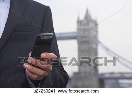 Stock Image - Business man using a mobile phone. Fotosearch