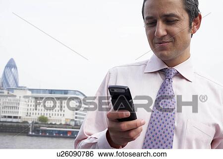 Business man using a mobile phone View Large Photo Image Stock Photograph - Business man using a mobile phone. Fotosearch