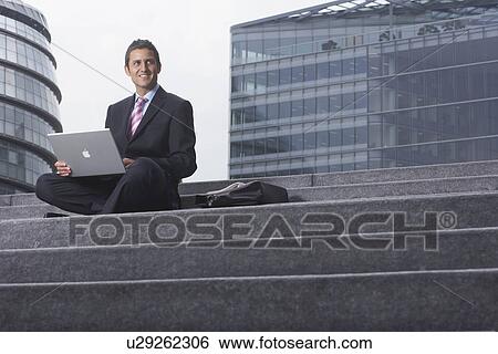 Stock Photograph - Business man with laptop outside. Fotosearch
