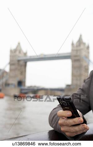 Stock Photograph - Business woman using mobile outside. Fotosearch
