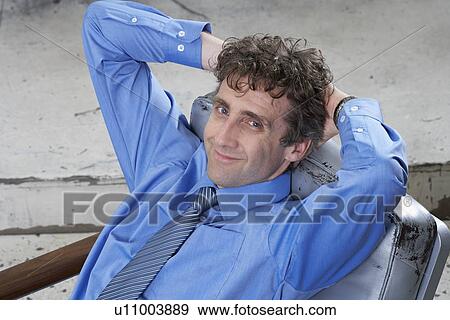 Stock Photo - Businessman, arms folded behind head. Fotosearch