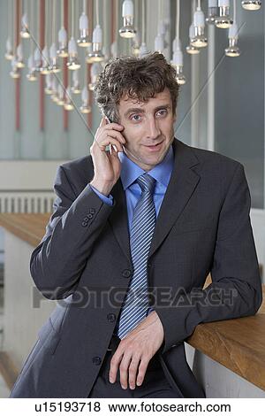 Stock Photo - Businessman at bar on his mobile. Fotosearch