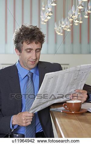 Businessman at bar reading paper, smile View Large Photo Image Stock Image - Businessman at bar reading paper, smile. Fotosearch