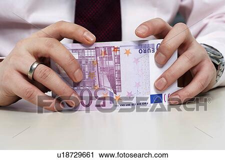 Stock Image - Businessman holding 500 euro notes. Fotosearch