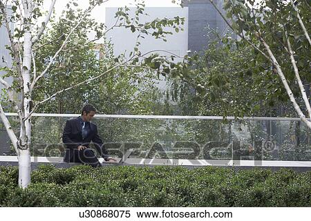 Stock Photography - businessman using laptop outside. Fotosearch